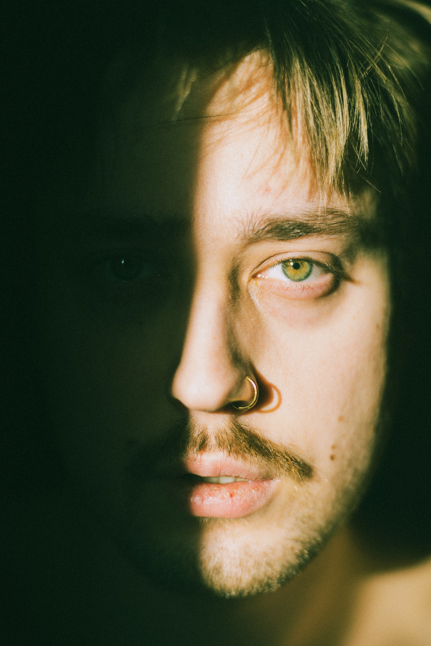Close colour portrait divided by green shadow and warm light.